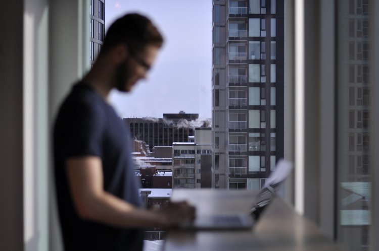 Sprzedaż nieruchomości – mężczyzna przegląda na laptopie oferty od agencji nieruchomości